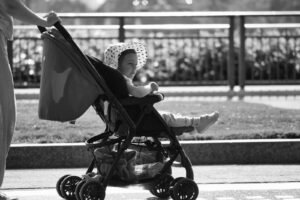 Madre empujando una silla de paseo ligera con su bebé en un día soleado de viaje
