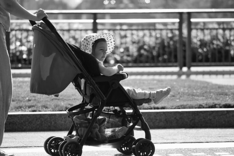 Madre empujando una silla de paseo ligera con su bebé en un día soleado de viaje