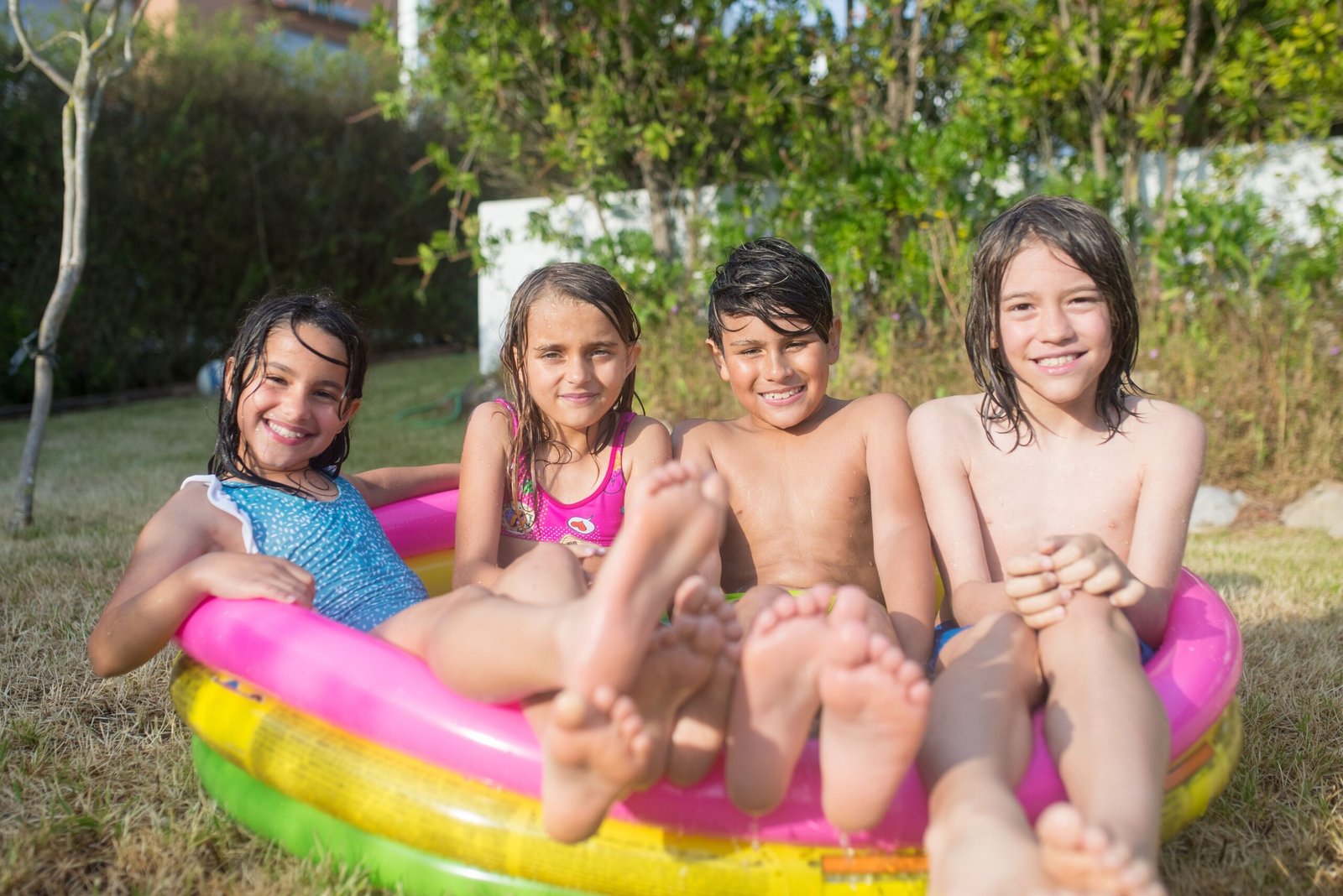 Niños divirtiéndose en una piscina inflable al aire libre en verano