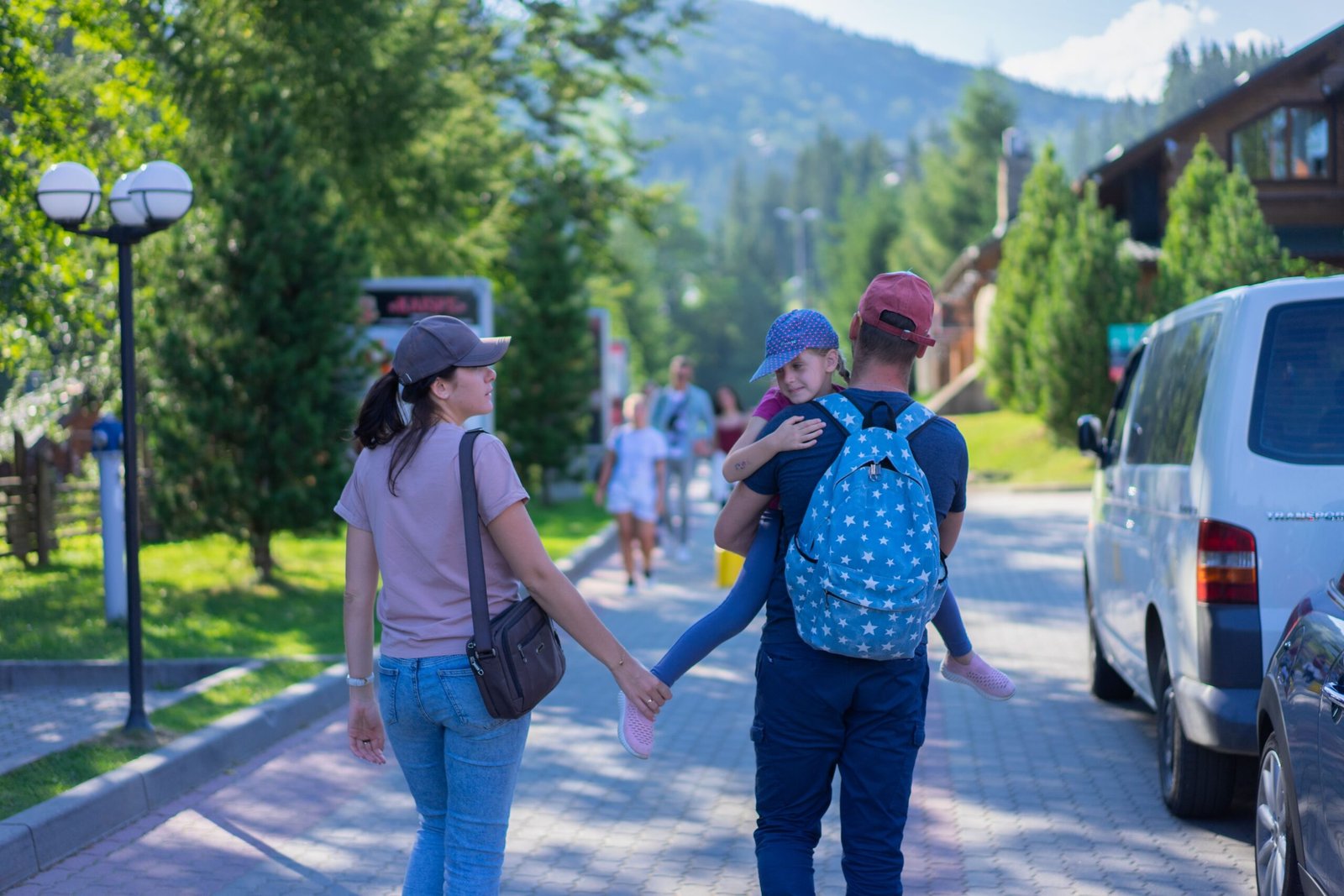 Padres caminando con su hija por un pueblo montañés en vacaciones