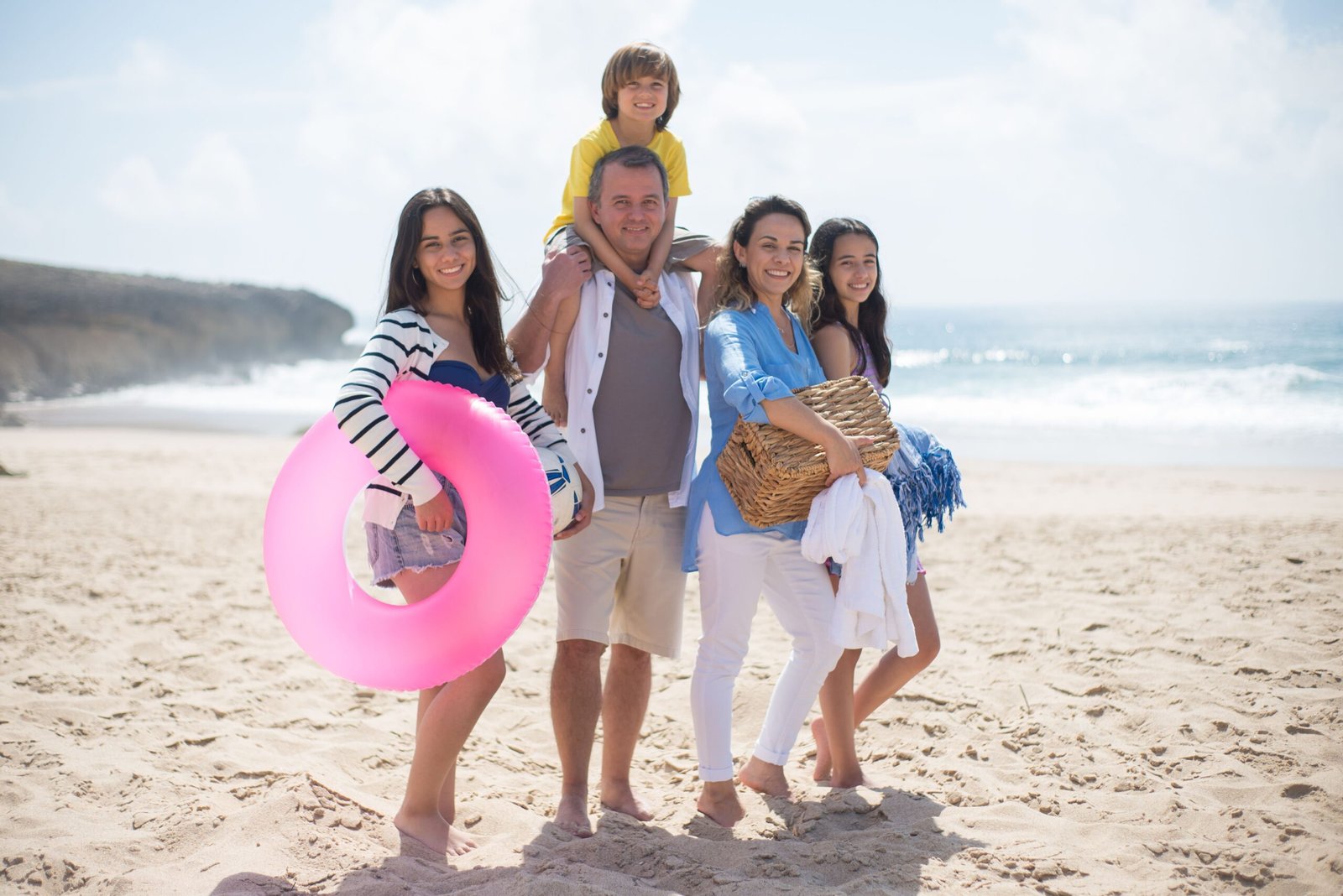 Familia numerosa posando feliz en una playa soleada de vacaciones
