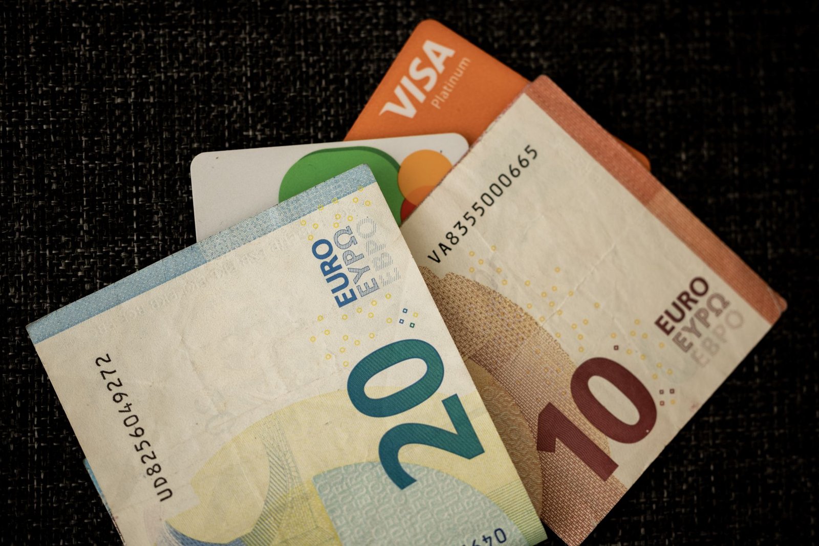 Billetes de euro y tarjetas de crédito sobre una superficie oscura