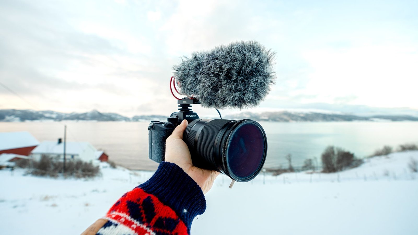 Cámara con micrófono externo grabando un paisaje nevado de Noruega para un vídeo de viaje