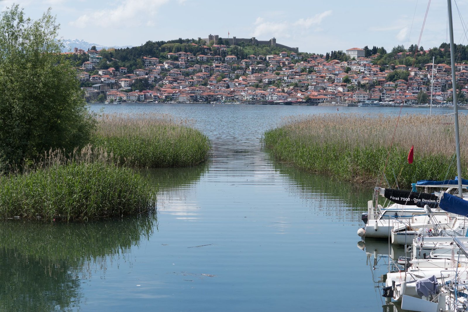 Vista panorámica del lago Ohrid con un pueblo en la colina