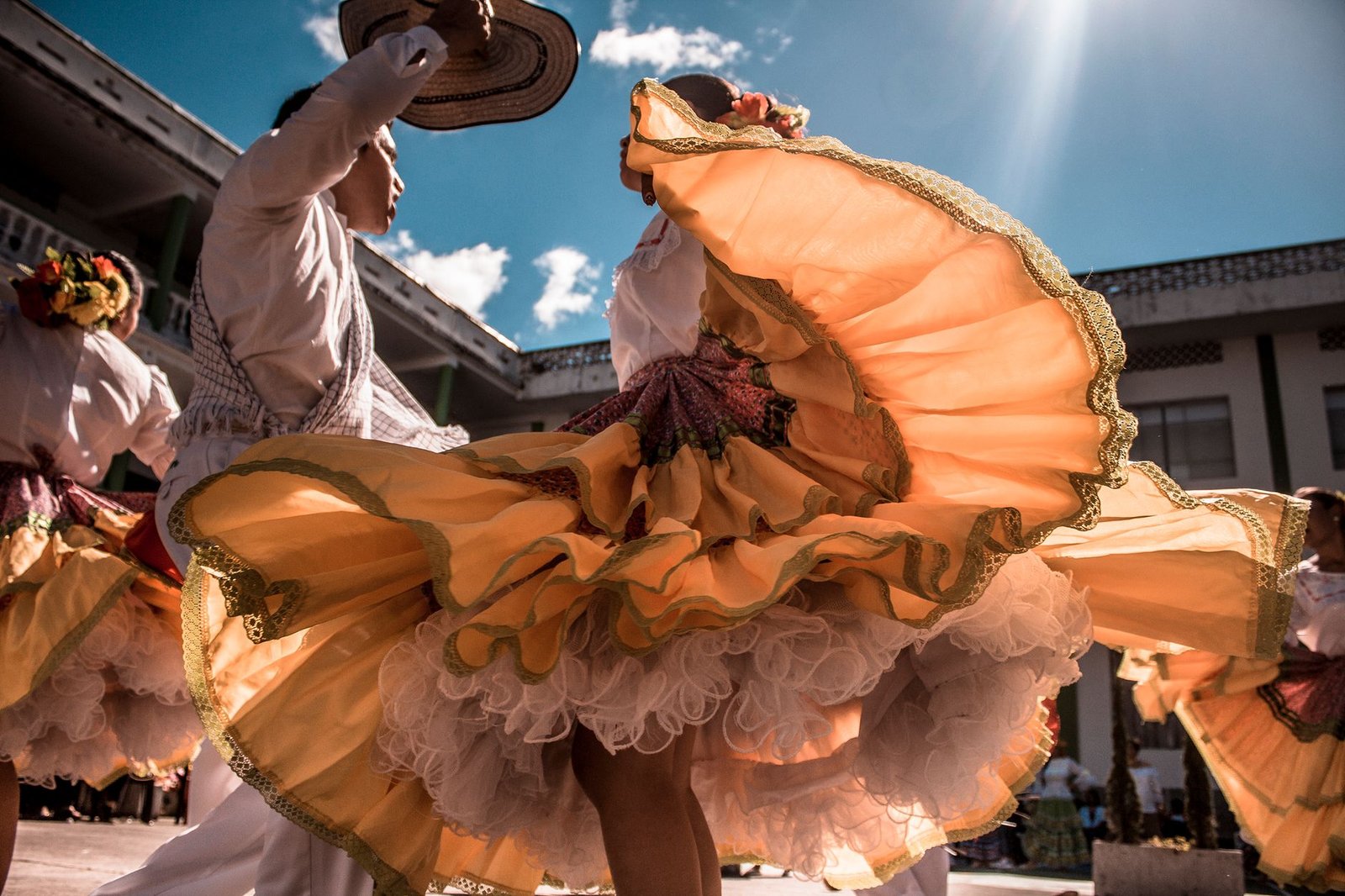 Pareja bailando sevillanas al aire libre con trajes tradicionales durante la feria