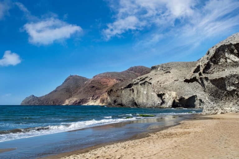 Acantilados y playa virgen del Parque Natural de Cabo de Gata bajo un cielo azul