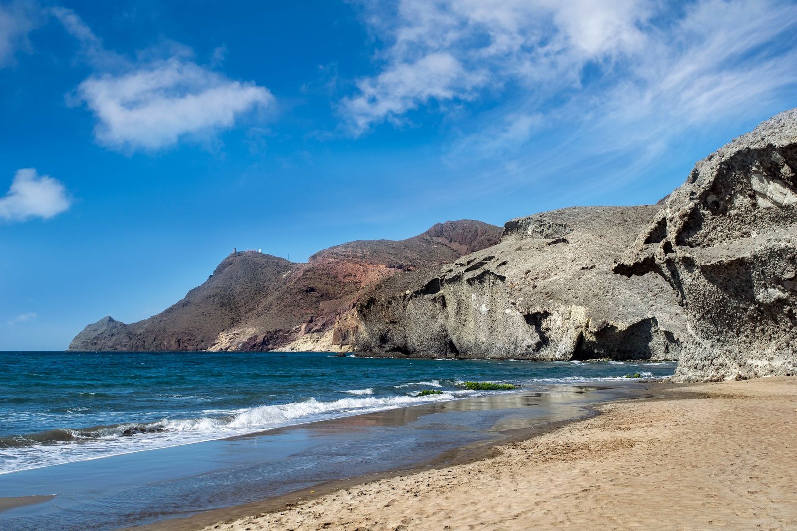 Acantilados y playa virgen del Parque Natural de Cabo de Gata bajo un cielo azul