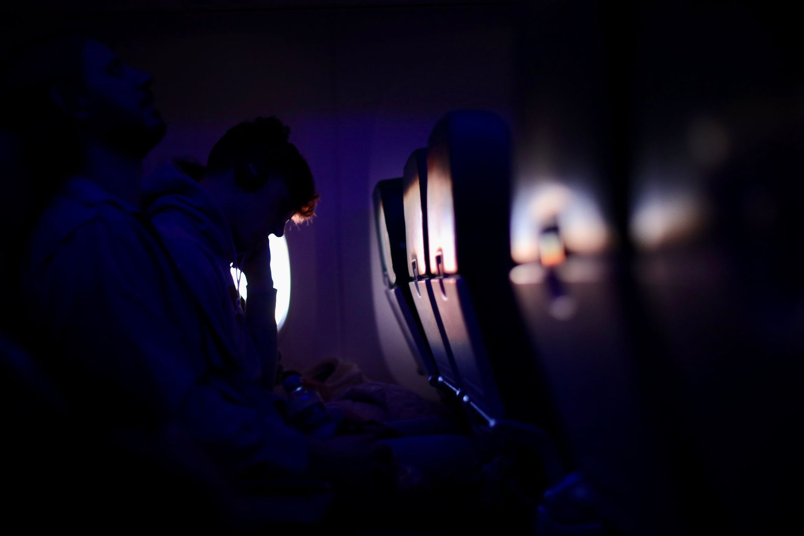 Pasajeros descansando en un avión con luz tenue