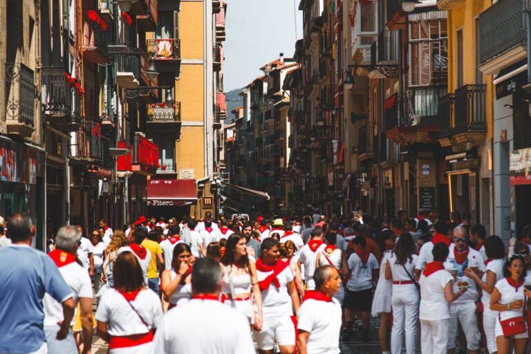 Calle de Pamplona con multitud vestida de blanco y rojo durante San Fermín