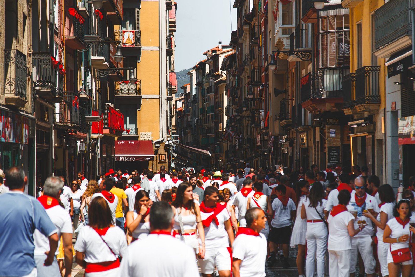 Calle de Pamplona con multitud vestida de blanco y rojo durante San Fermín