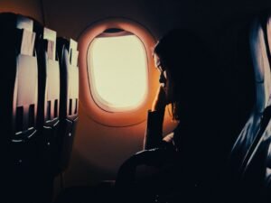 Mujer descansando junto a la ventanilla en un vuelo largo
