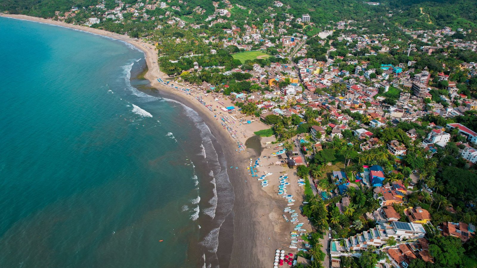 Vista aérea de Sayulita, con el pueblo y aguas turquesa en la costa de Nayarit