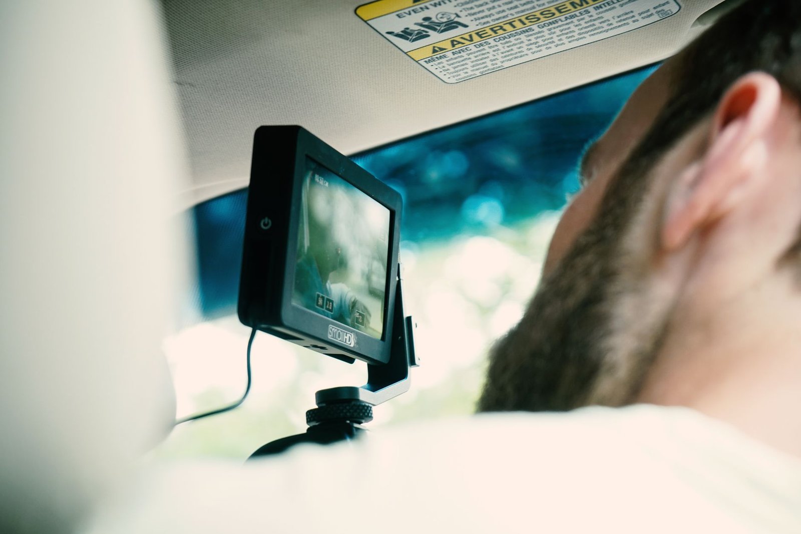 Conductor usando una dashcam montada en el parabrisas del coche