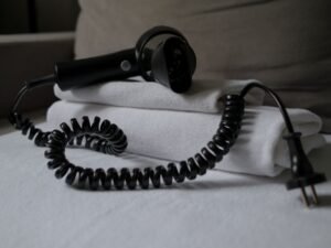 Secador de pelo sobre toallas blancas dobladas en el baño de un hotel