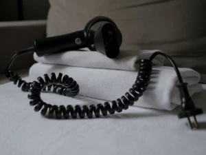 Secador de pelo sobre toallas blancas dobladas en el baño de un hotel