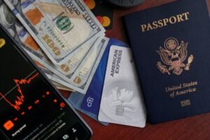 Pasaporte, tarjetas de crédito, billetes y móvil sobre una mesa, preparados para un viaje al extranjero
