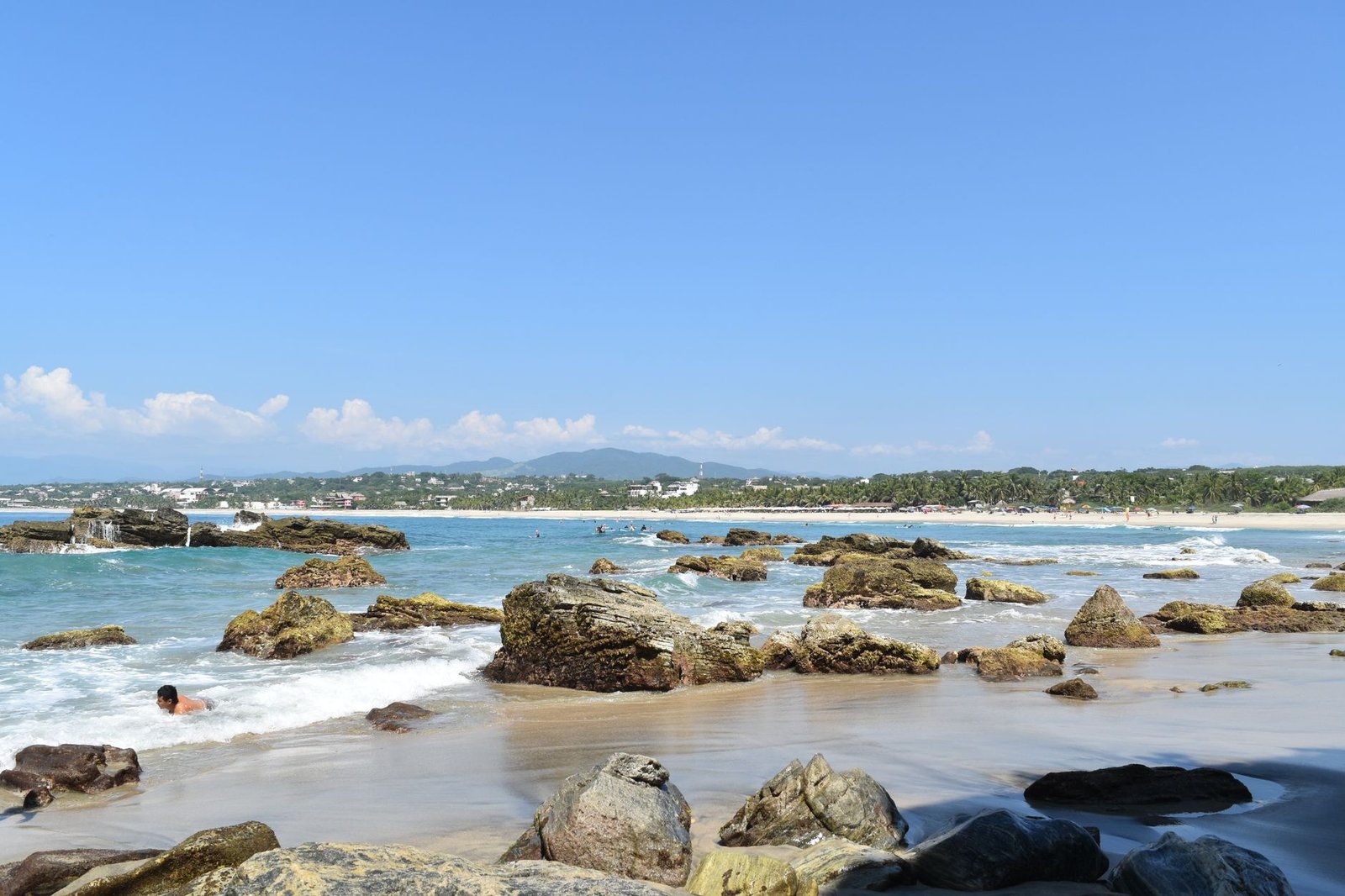 Playa de Puerto Escondido, en Oaxaca, con costa rocosa y cielo despejado