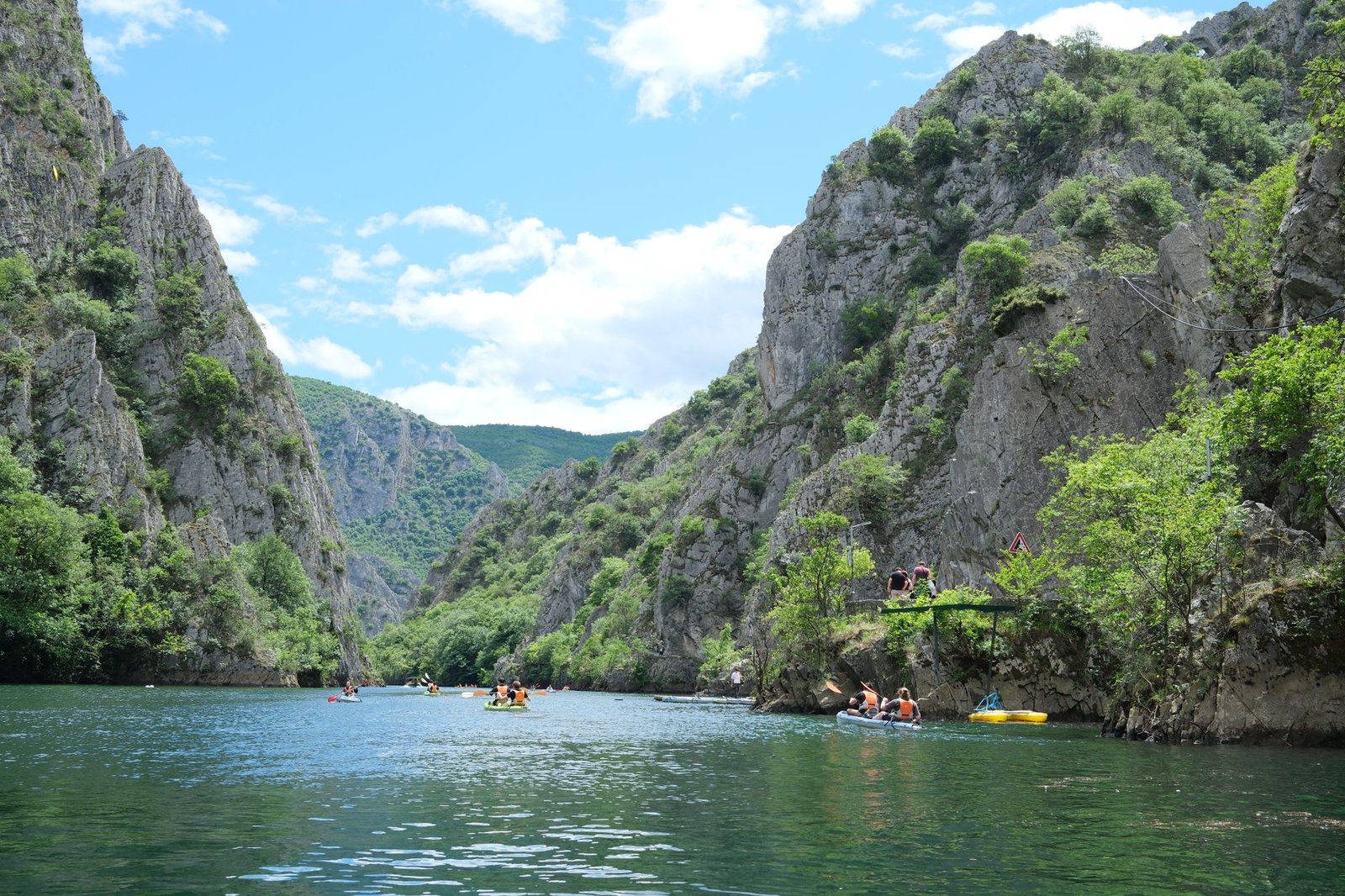 Piragüistas remando entre las paredes verticales de un cañón fluvial