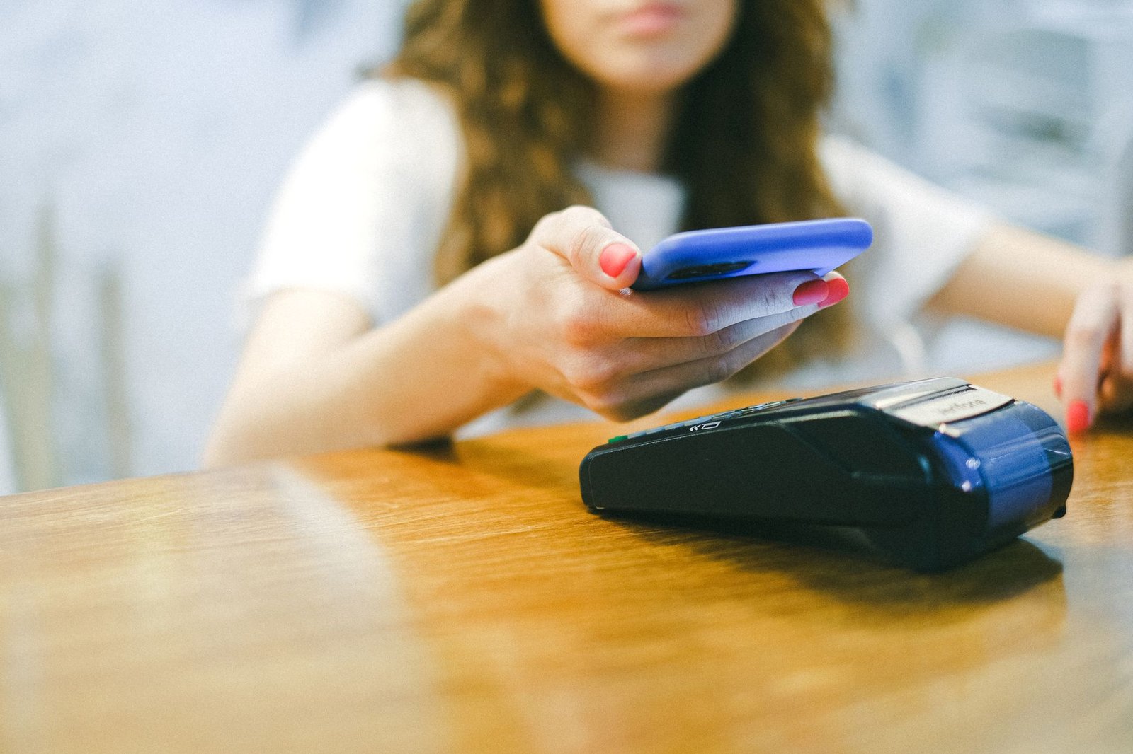 Mujer pagando sin contacto con el móvil en un datáfono