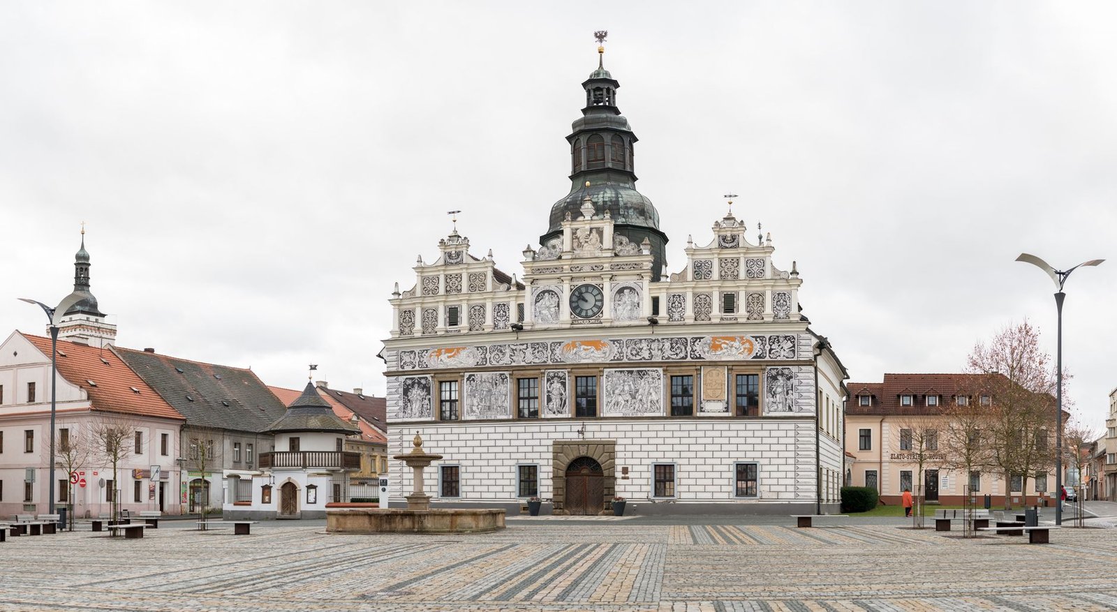 Plaza porticada renacentista con edificios históricos de piedra y suelo empedrado, similar a la Plaza Mayor de Alcaraz