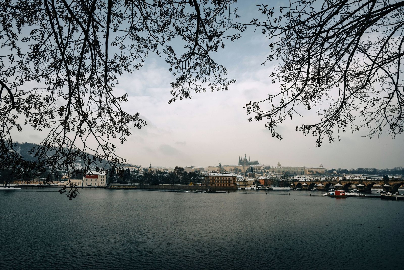 Vista invernal del castillo de Praga y el puente de Carlos sobre el río