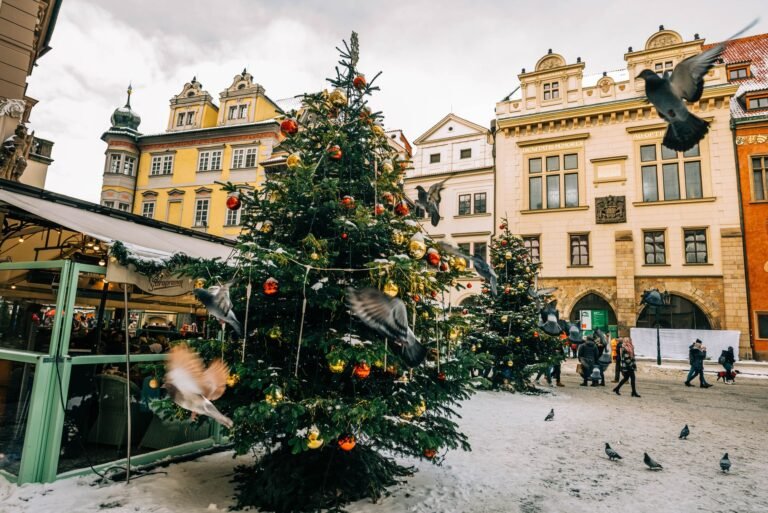 Mercado de Navidad en una plaza nevada de Praga con árboles decorados
