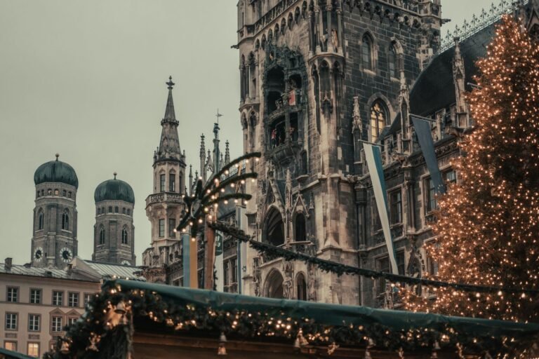 Mercado de Navidad del Marienplatz de Múnich con edificios históricos y luces al fondo