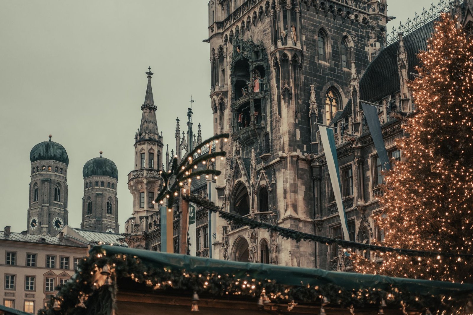 Mercado de Navidad del Marienplatz de Múnich con edificios históricos y luces al fondo