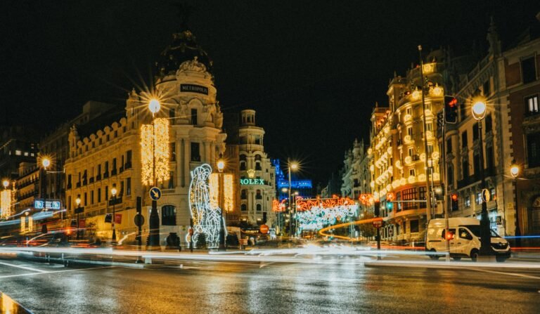 Gran Vía de Madrid de noche con luces navideñas y el edificio Metrópolis iluminado