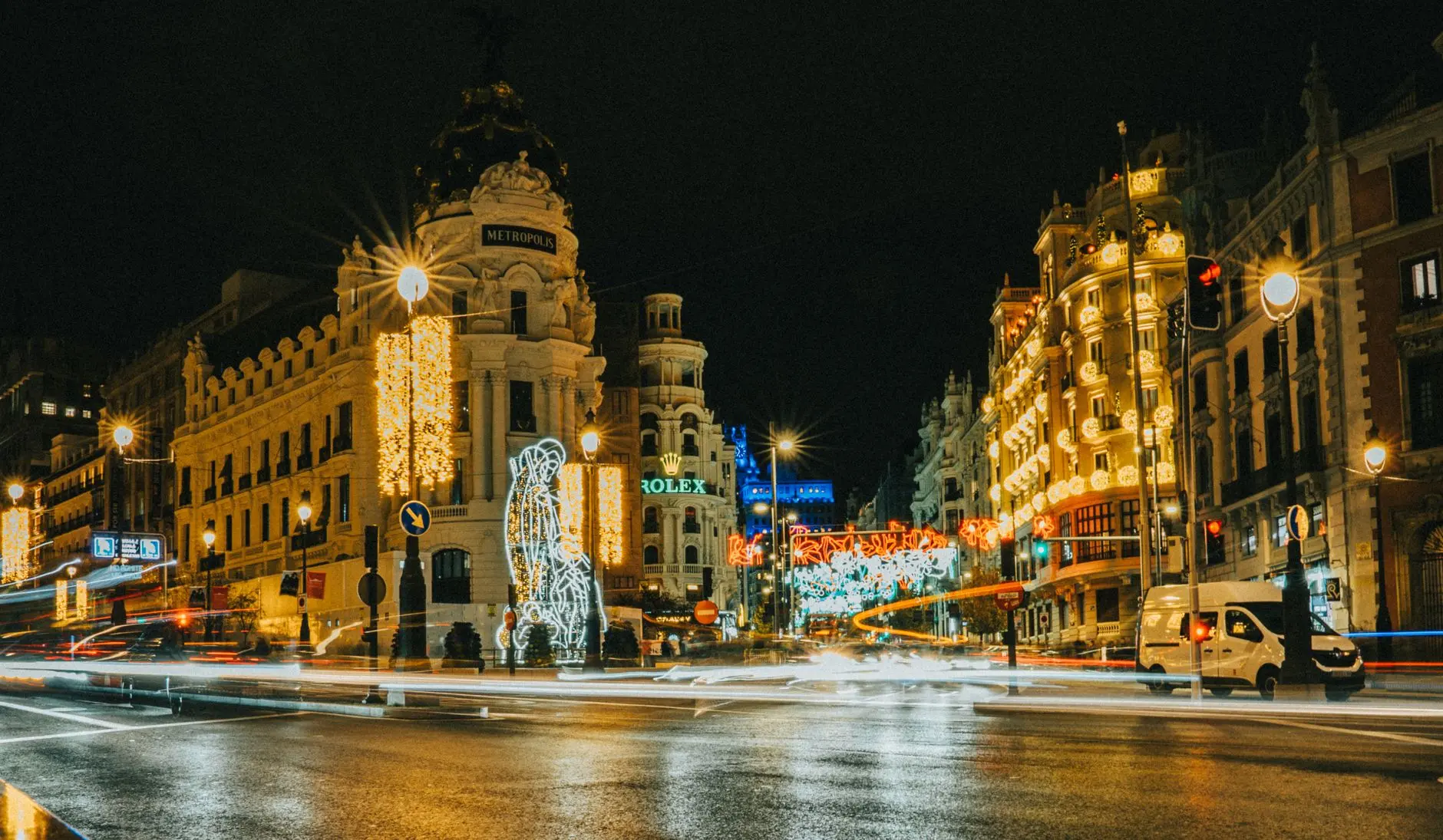 Gran Vía de Madrid de noche con luces navideñas y el edificio Metrópolis iluminado