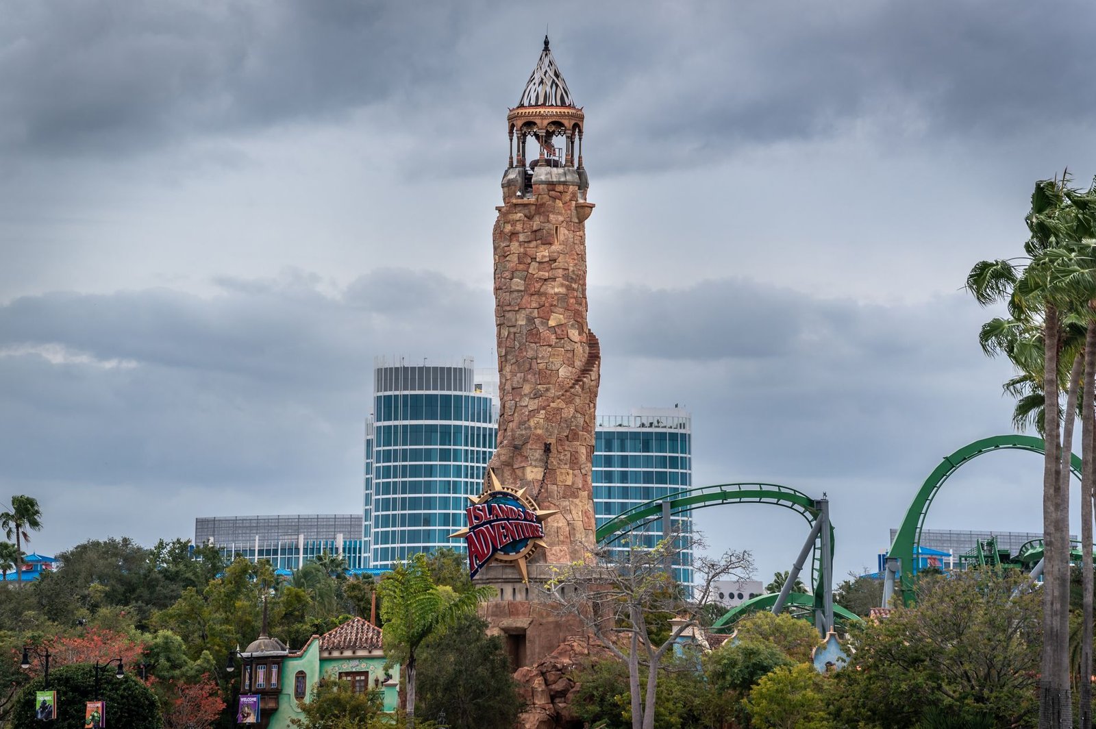 Torre del faro de Islands of Adventure con una montaña rusa verde en Universal Orlando