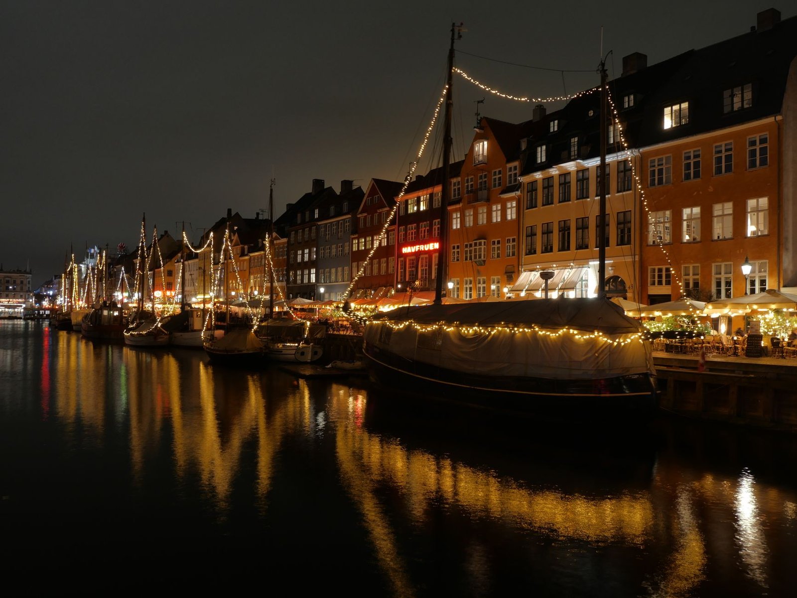 Vista nocturna de Nyhavn en Copenhague con luces navideñas