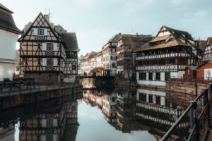 Casas con entramado de madera reflejadas en un canal de la Petite France de Estrasburgo