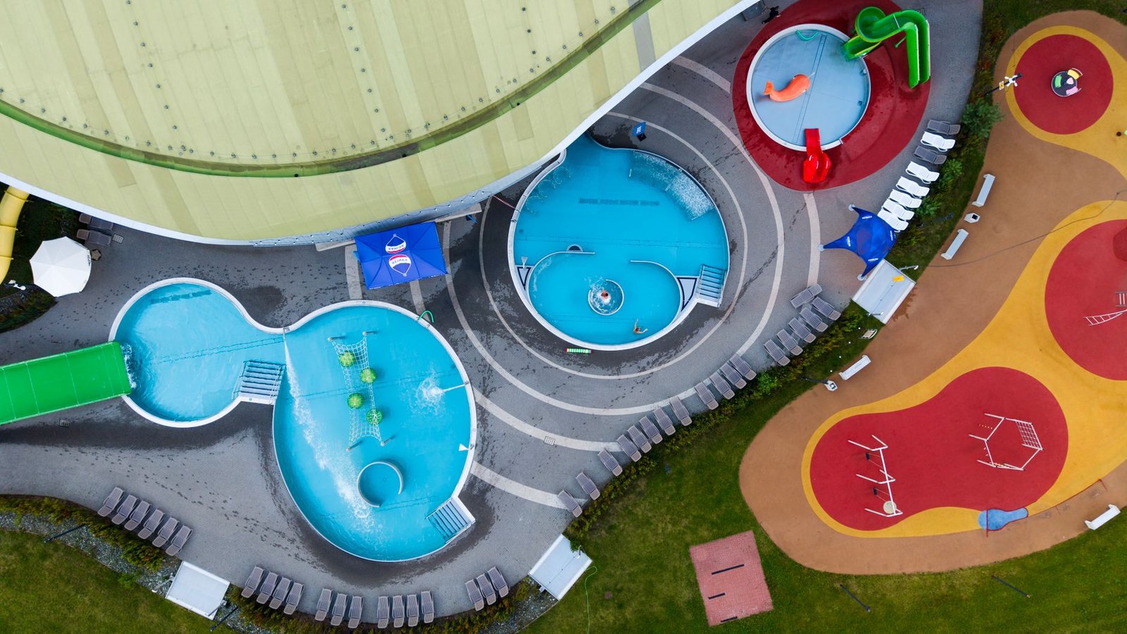 Vista aérea de un parque acuático con toboganes y albercas, similar a Six Flags Hurricane Harbor Oaxtepec