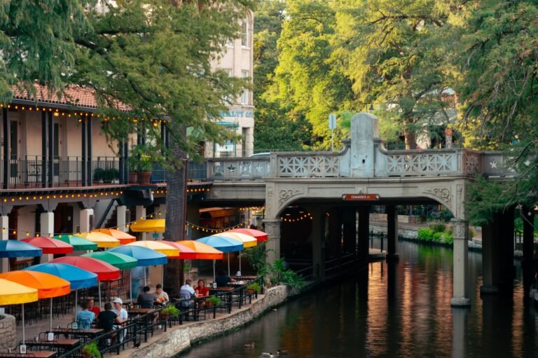 Terrazas con sombrillas de colores junto al canal del River Walk de San Antonio, Texas