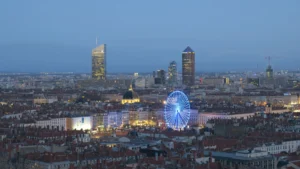 Vista aérea nocturna de Lyon con la noria iluminada durante la Fête des Lumières
