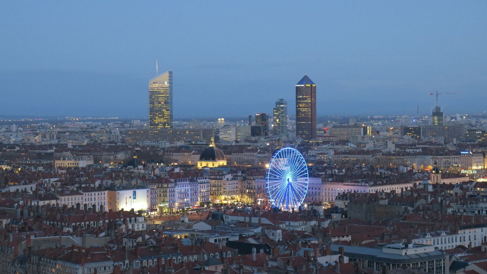 Vista aérea nocturna de Lyon con la noria iluminada durante la Fête des Lumières