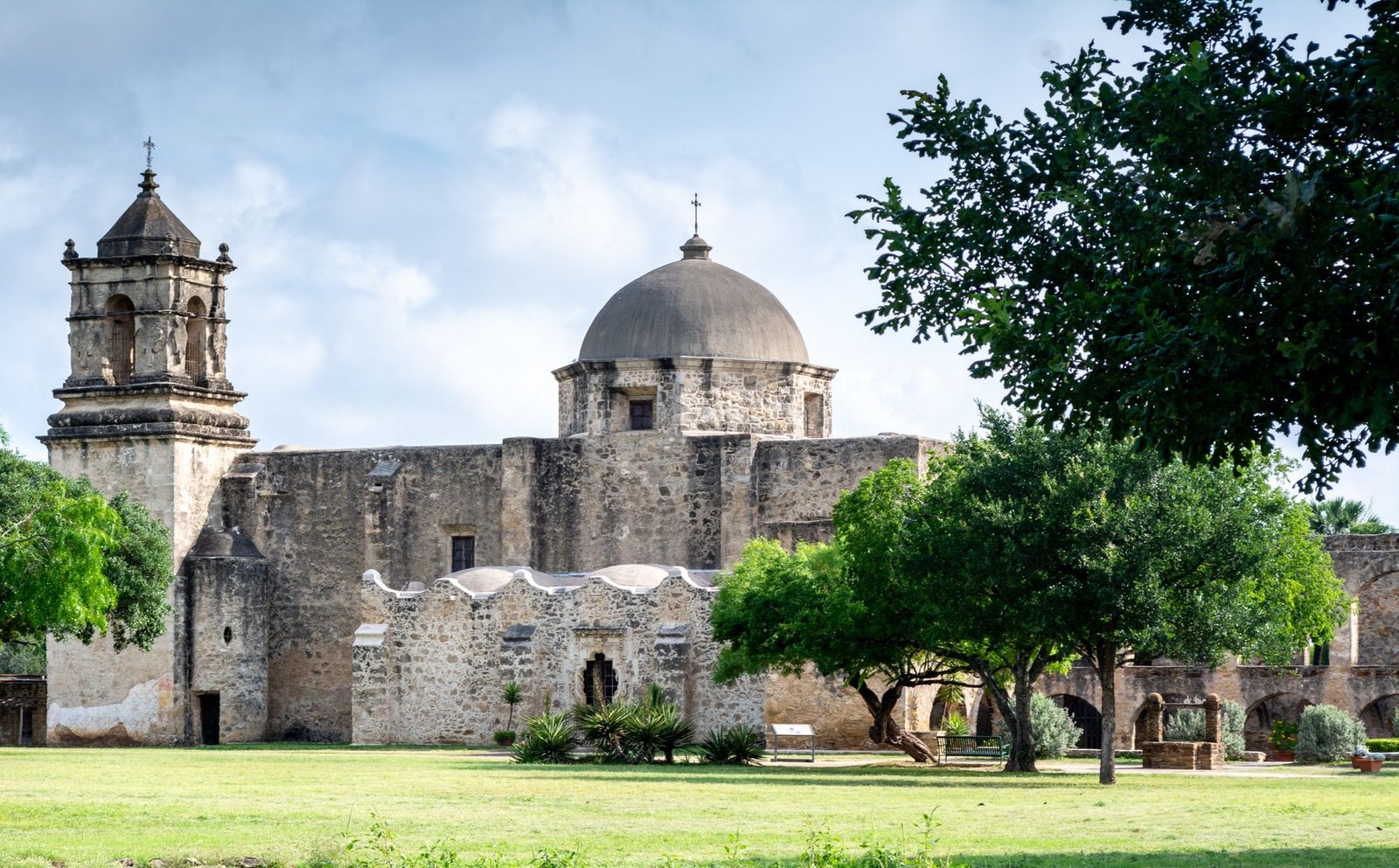Misión San José, en San Antonio, Texas, con su torre y su cúpula entre árboles