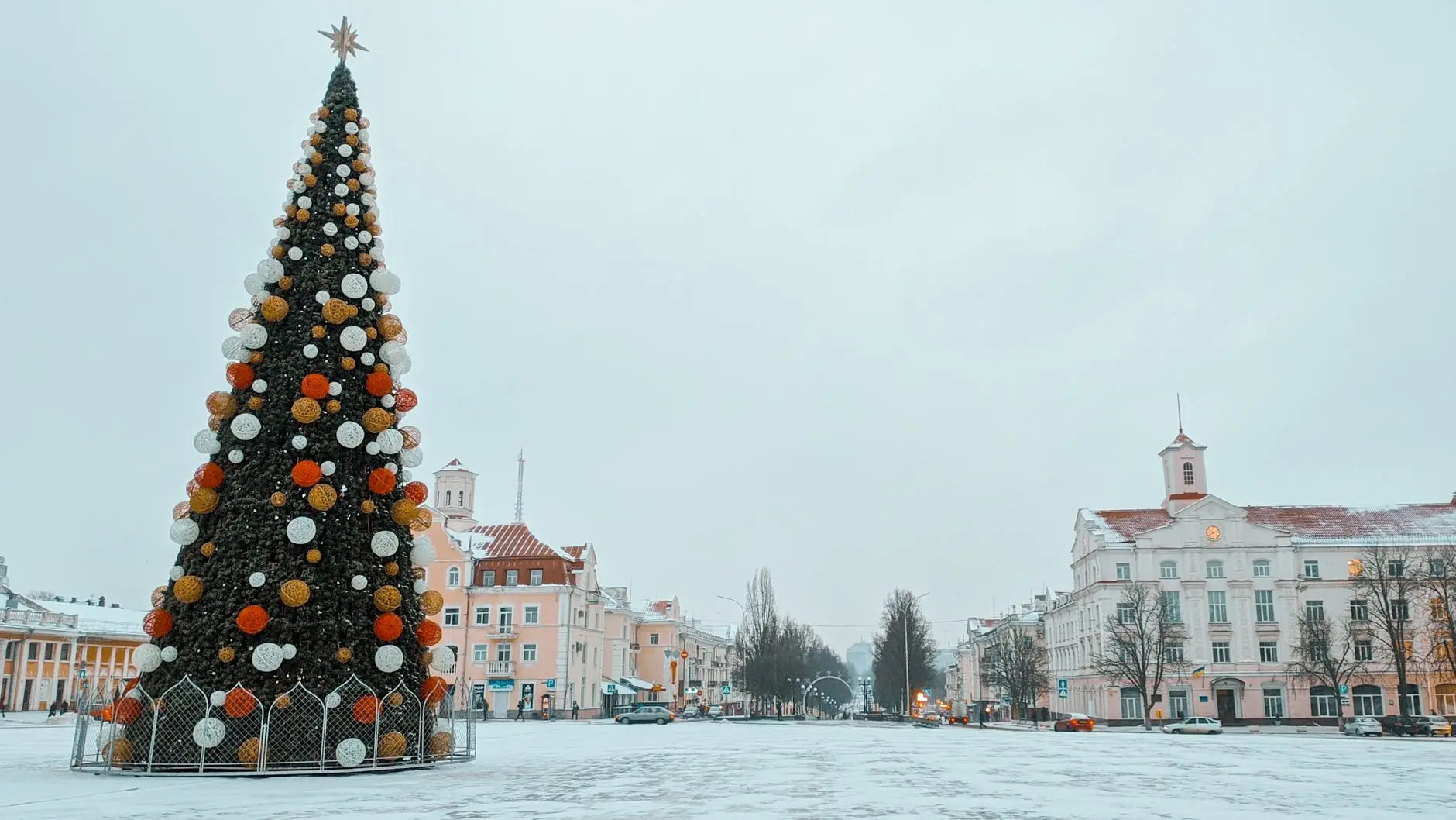 Plaza nevada con un gran árbol de Navidad decorado y luces