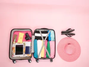 Maleta abierta organizada con accesorios de viaje, lista para un regalo práctico