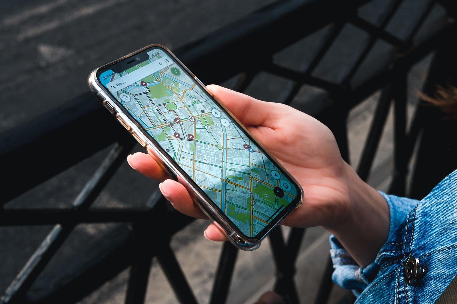 Mano sosteniendo un smartphone con una aplicación de mapas abierta al aire libre